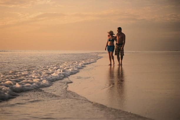 Couple having a sunset walk on the beach in Broome