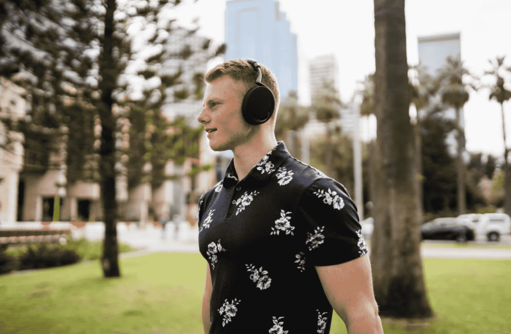 Student listening to music on Perth foreshore wearing flowery shirt
